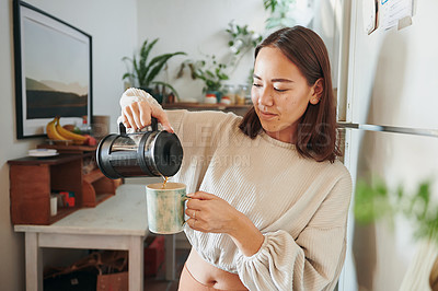 Buy stock photo Shot of a young woman pouring herself a cup of coffee