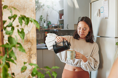 Buy stock photo Shot of a young woman pouring herself a cup of coffee