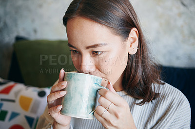 Buy stock photo Shot of a young woman enjoying a cup of coffee