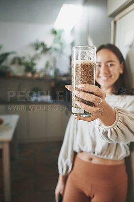 Buy stock photo Shot of a young woman holding her smoothie before drinking it..