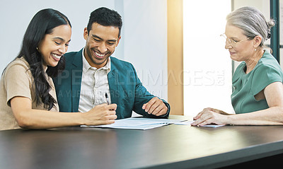 Buy stock photo Cropped shot of a young couple going over some paperwork during a meeting with their financial advisor