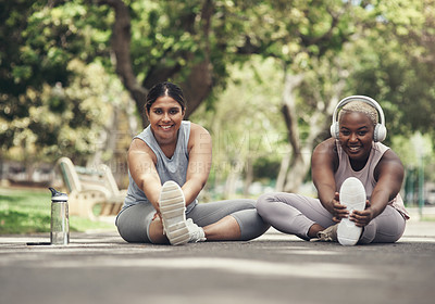 Buy stock photo Shot of two young woman taking a break during their workout