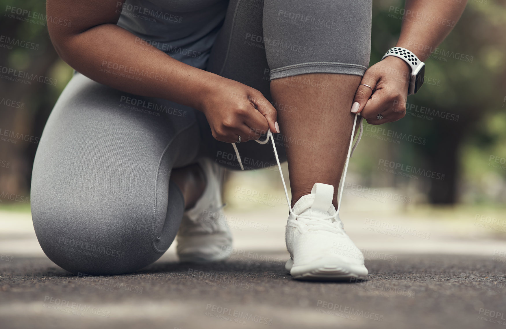 Buy stock photo Shot of a woman tying her shoes before working out