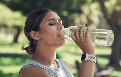 Buy stock photo Shot of a young woman taking a break during a workout to drink water