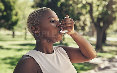 Buy stock photo Shot of a young woman taking a break during a workout to use her asthma pump