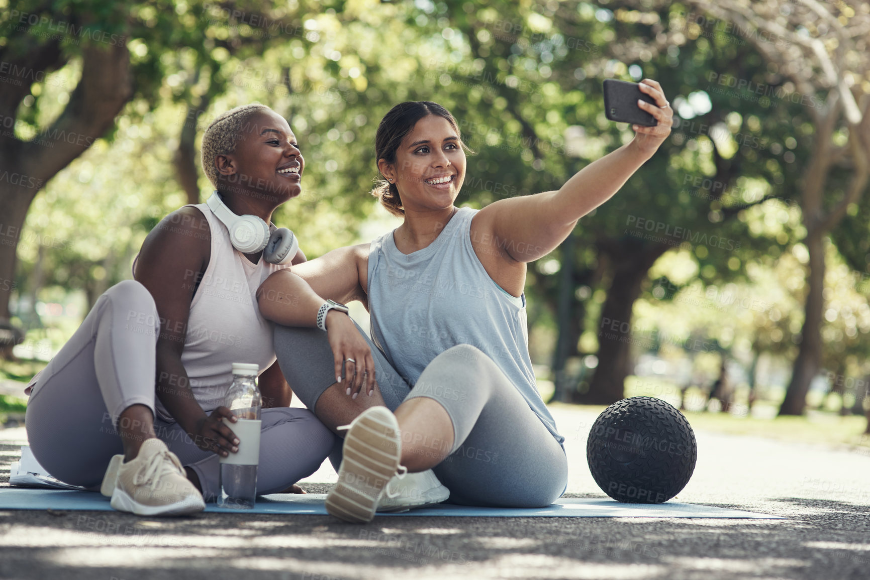 Buy stock photo Shot of two young female friends taking a break during their workout to take selfies
