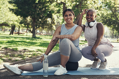 Buy stock photo Shot of two friends taking a break during their workout