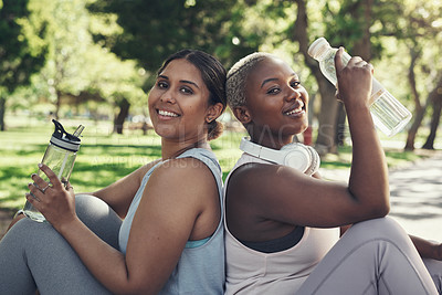 Buy stock photo Shot of two friends taking a break during their workout