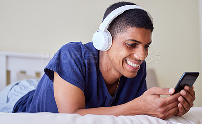 Buy stock photo Shot of a young man using his phone at home