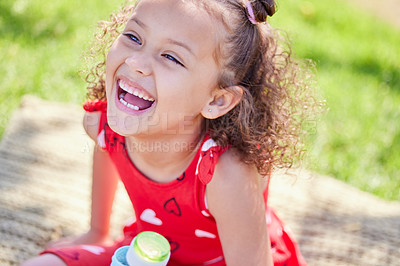 Buy stock photo Girl, child and happy on picnic blanket in park, garden or nature to relax on holiday in summer. Kid, smile and excited with laughing, joke and comic memory in sunshine on grass field for vacation