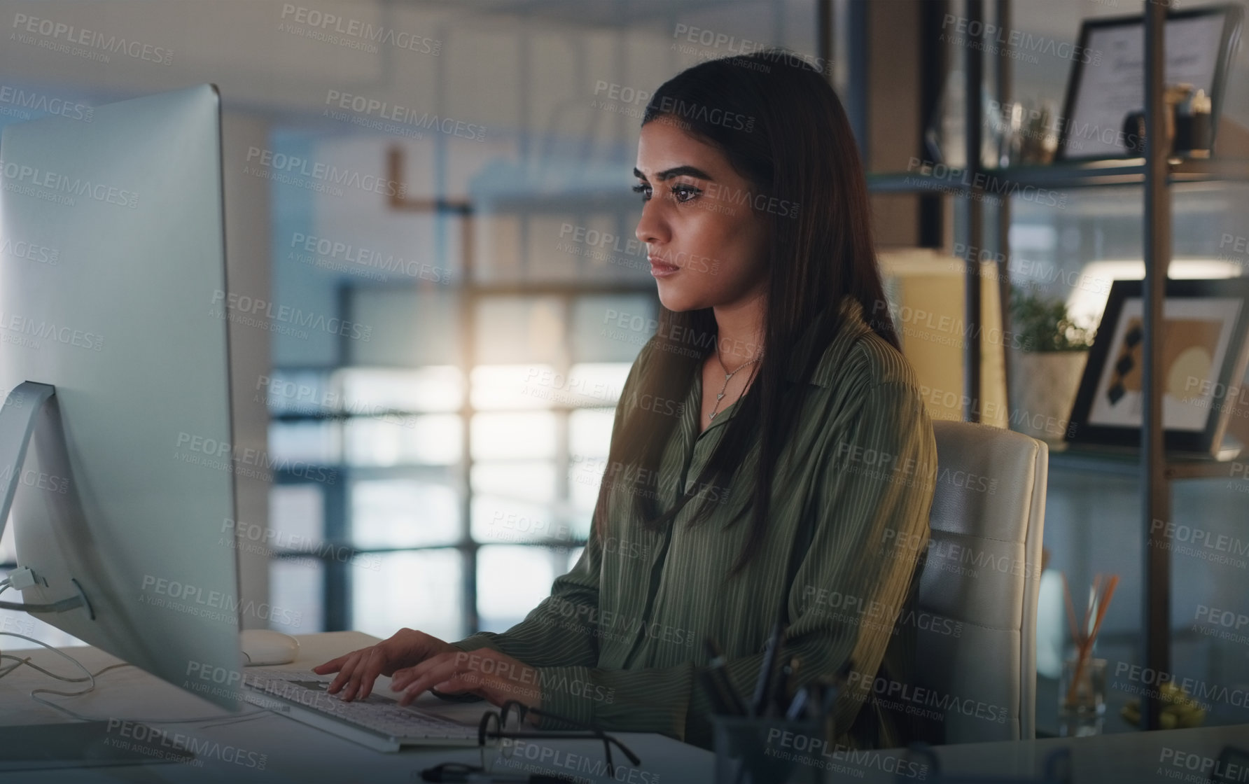 Buy stock photo Shot of a young businesswoman working on a computer in an office at night