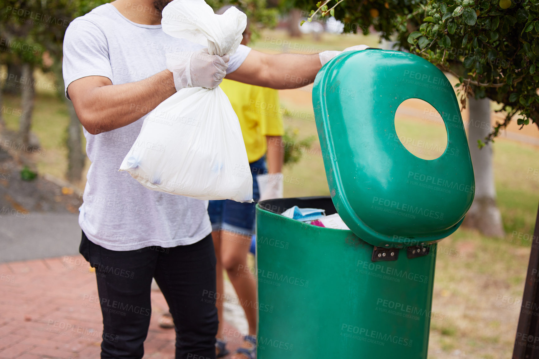 Buy stock photo Volunteer cleaning, trash bin and man throw garbage, pollution or waste product for environment support. Community help, NGO charity and eco friendly people helping with nature park plastic clean up