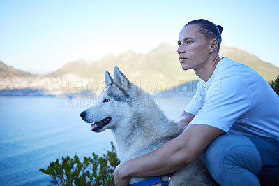 Buy stock photo Cropped shot of a handsome young man and his pet husky enjoying an early morning hike in the mountains