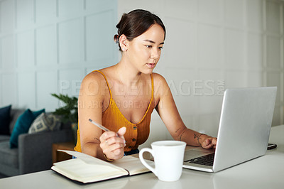 Buy stock photo Laptop, notes and woman writing in kitchen working on creative freelancer project at home. Technology, reading and Asian female writer planning in notebook with computer by counter at apartment.