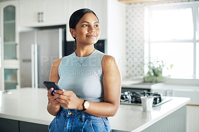Buy stock photo Happy, cellphone and woman in kitchen scroll on mobile app, internet or website at apartment. Smile, phone and young female person networking online and reading email by counter at modern home.