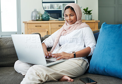 Buy stock photo Muslim, woman and couch to relax on laptop at home in living room with digital technology for online content. Traditional, islam and hijab person on internet to connect to culture for Eid blog
