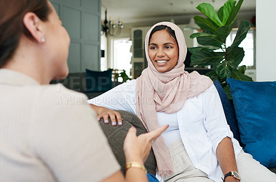 Buy stock photo Friends, gossip and talk on sofa for bonding, relax and speaking in home on weekend and cozy. Women, muslim hijab and support or care in conversation, sisterhood and happy for chatting on couch