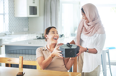 Buy stock photo Kitchen, women and friends, gift and smile for box, thank you and birthday in house, ribbon and care. Home, hijab and Muslim female person with present, package and kindness and happy with gratitude
