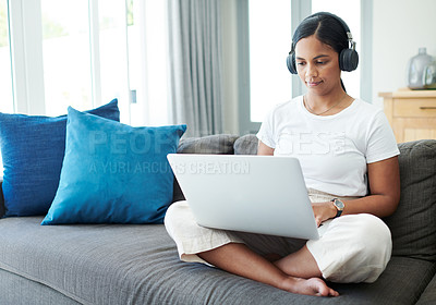Buy stock photo Woman, laptop and headphones for remote work on couch, check email and freelancer on website in home. Female person, app and planning on internet, copywriting and research on project or networking