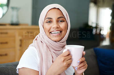 Buy stock photo Portrait, smile and woman drinking coffee in home for breakfast, espresso or latte in the morning on sofa in house. Tea cup, face and happy person in hijab in living room to relax or laugh in Dubai