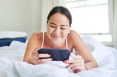 Buy stock photo Woman, bed and phone for watching on internet, website and smile for comedy or relax in home. Happy female person, online and streaming series or movie, social network and morning or app for film