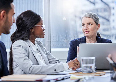 Buy stock photo Shot of a mature businesswoman having a meeting with her colleagues in a boardroom