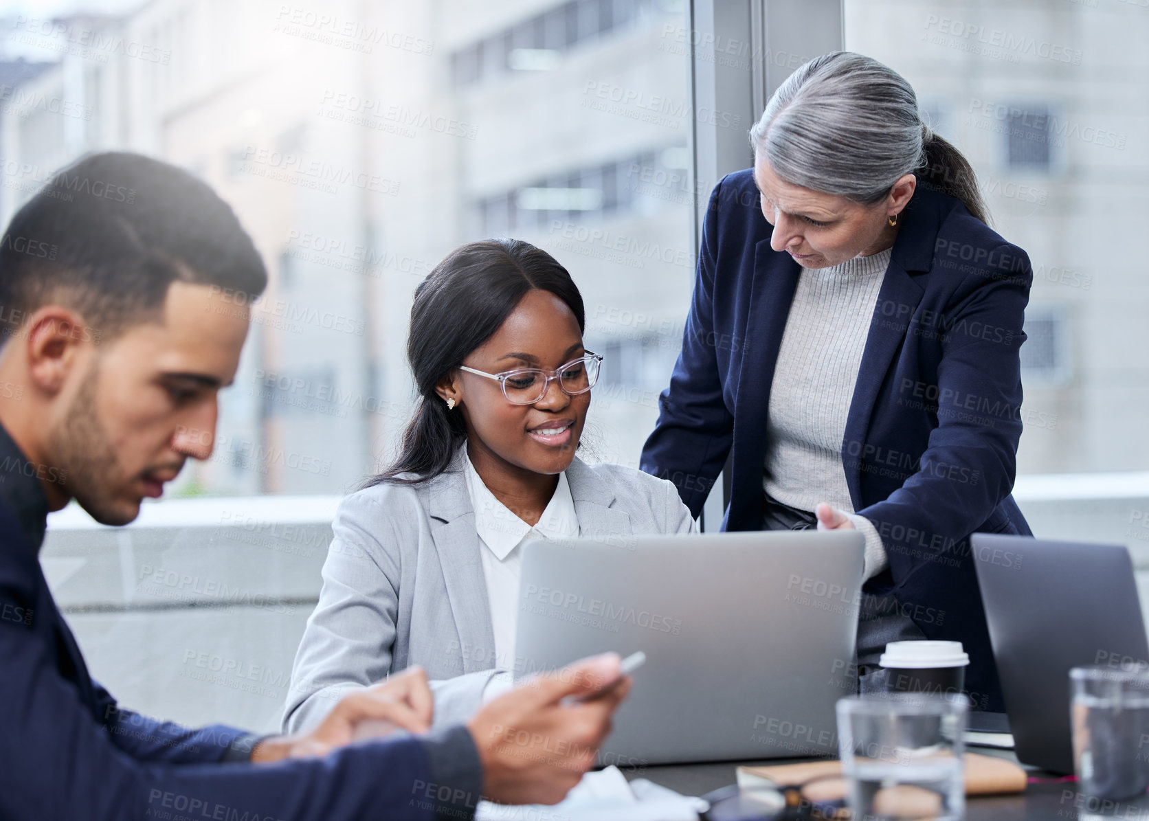 Buy stock photo Shot of two businesswomen working together on a laptop in an office