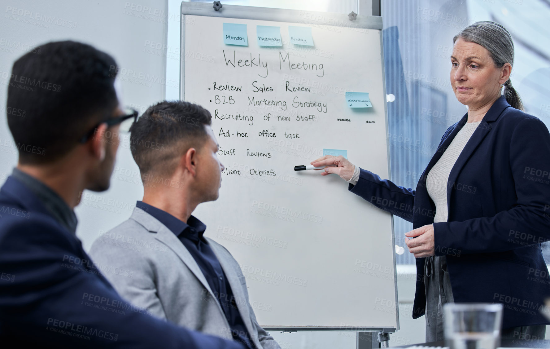 Buy stock photo Shot of a mature businesswoman using a whiteboard during a presentation to her colleagues in an office