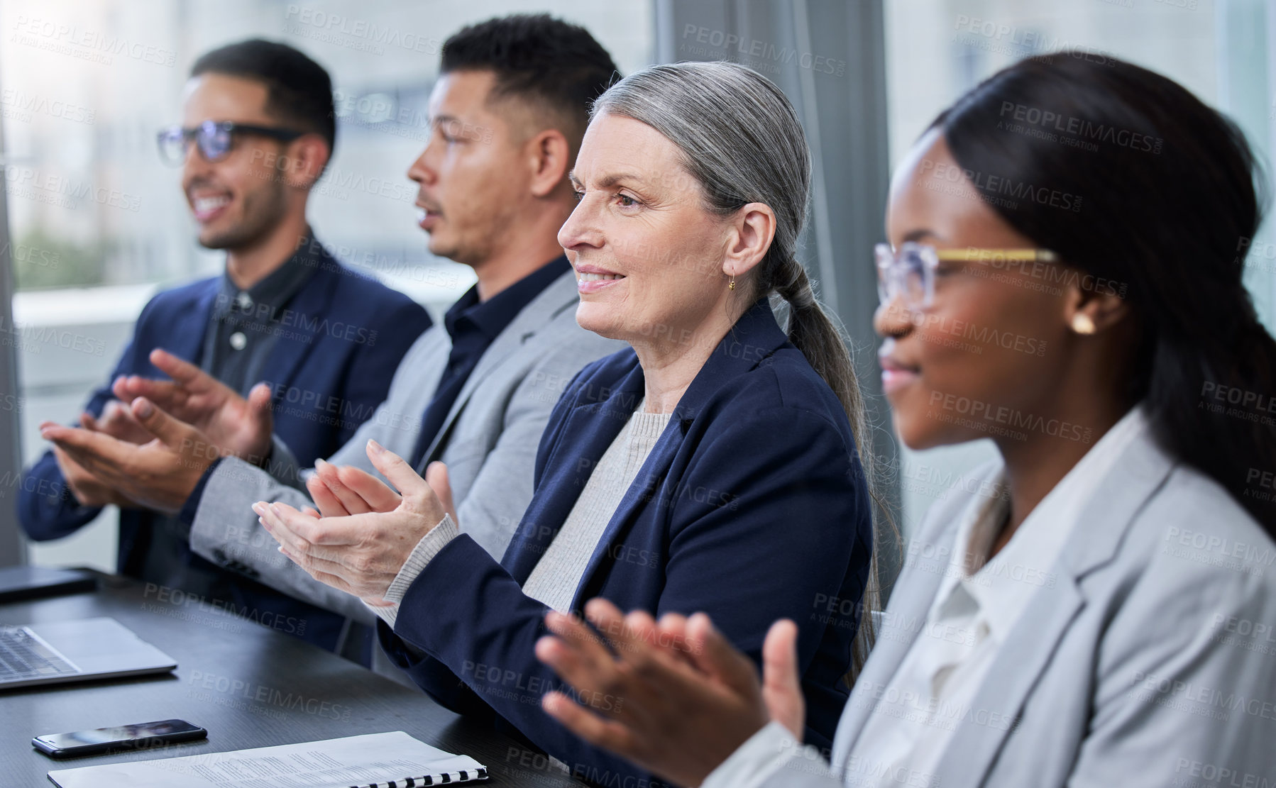 Buy stock photo Shot of a mature businesswoman applauding with her colleagues during a meeting in an office