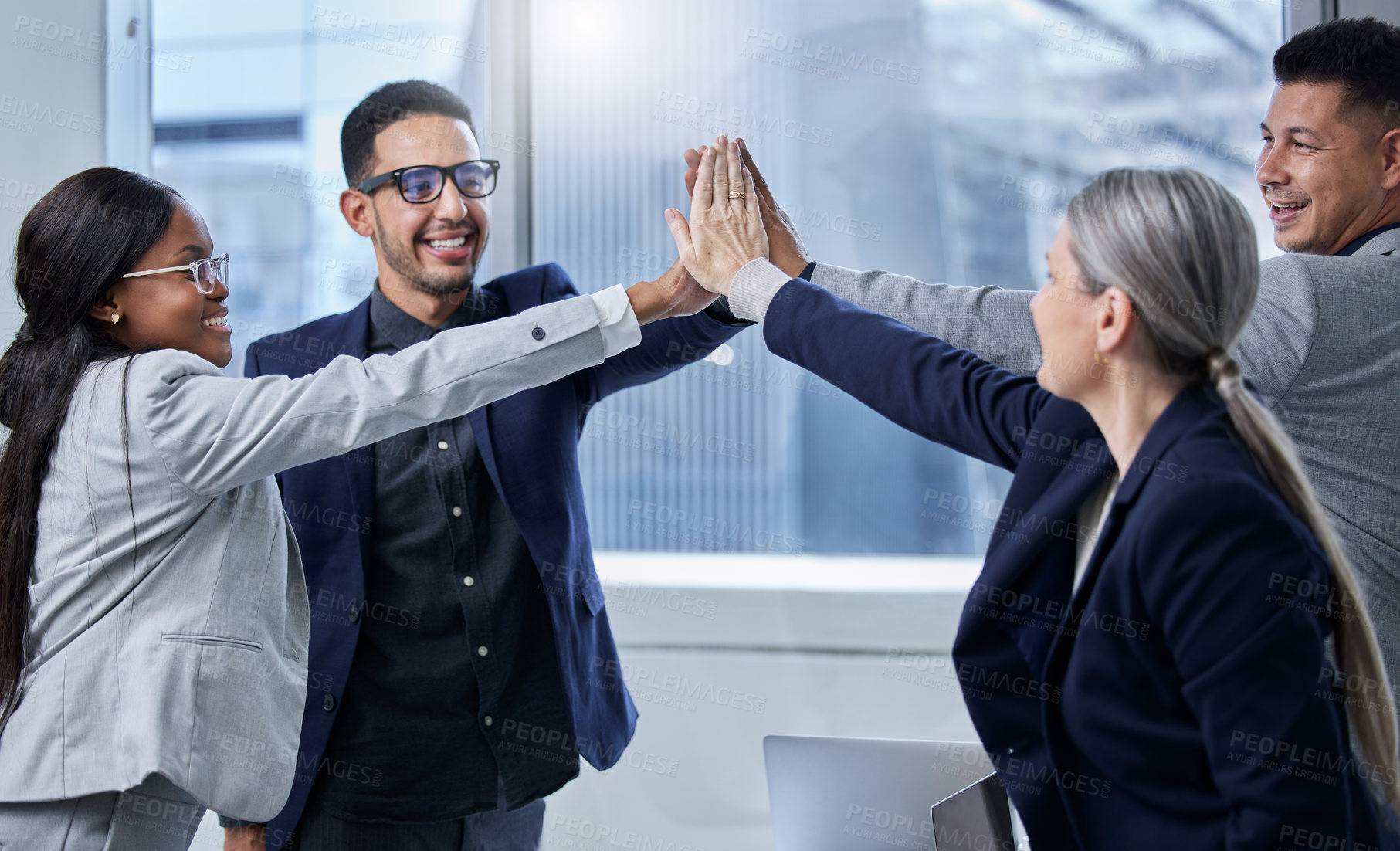 Buy stock photo Shot of a group of businesspeople giving each other a high five in an office