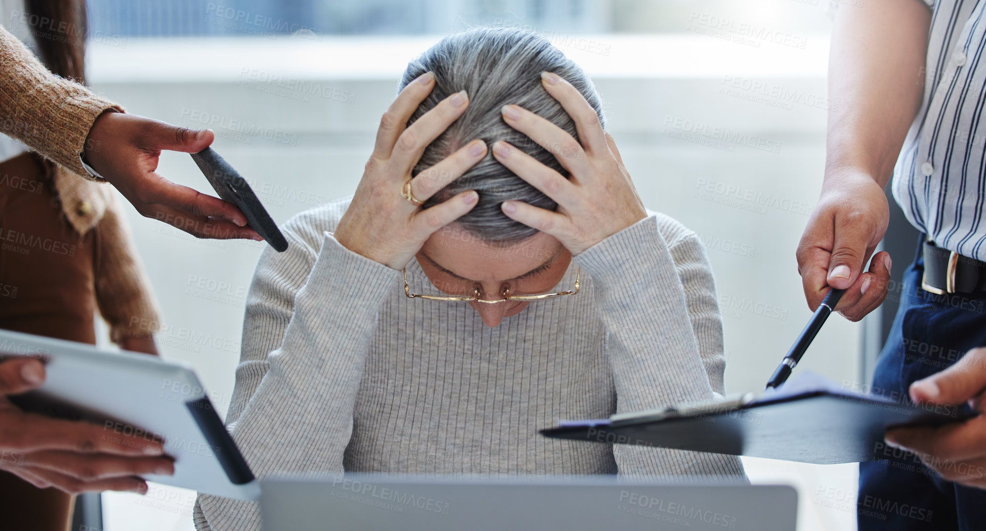 Buy stock photo Shot of a mature businesswoman sitting in the office and feeling stressed while colleagues overwhelm her with tasks