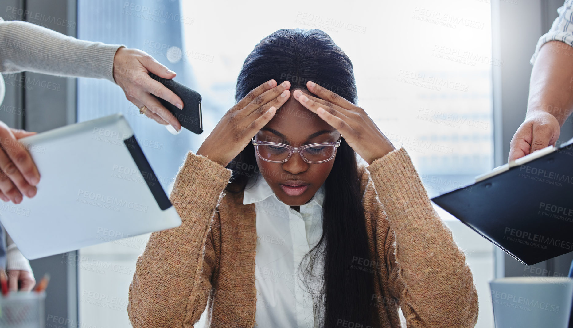 Buy stock photo Shot of a young businesswoman sitting in the office and feeling stressed while colleagues overwhelm her with tasks