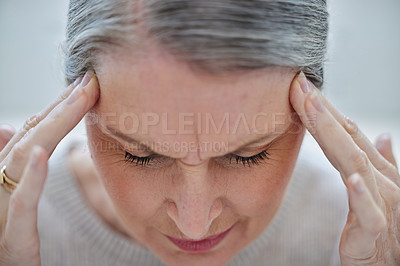 Buy stock photo Shot of a mature businesswoman sitting alone in the office and suffering from a headache