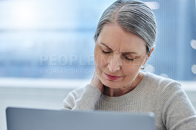 Buy stock photo Shot of a mature businesswoman sitting alone in the office and suffering from a sore neck