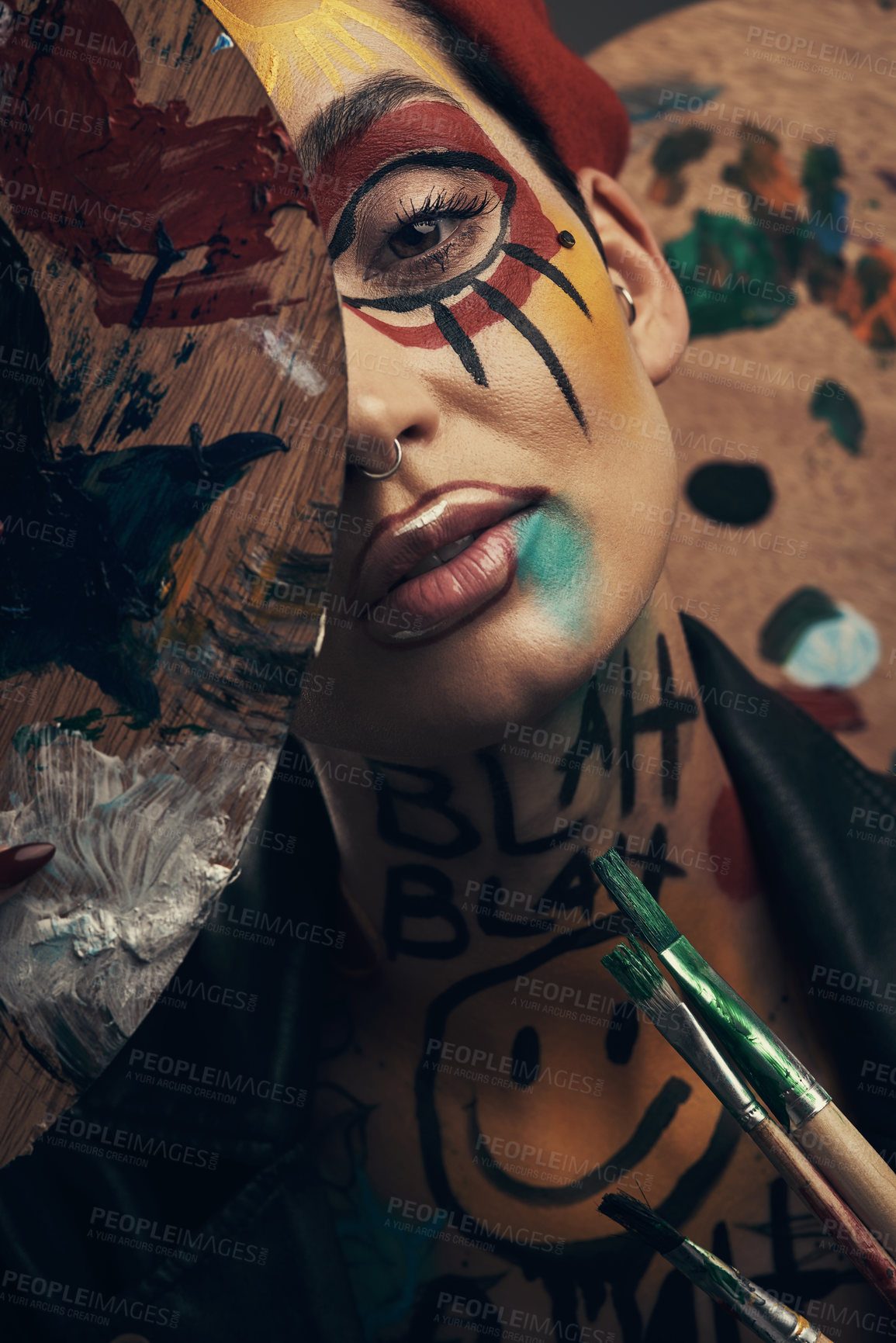 Buy stock photo Studio shot of a young woman posing with paint on her face on a grey background