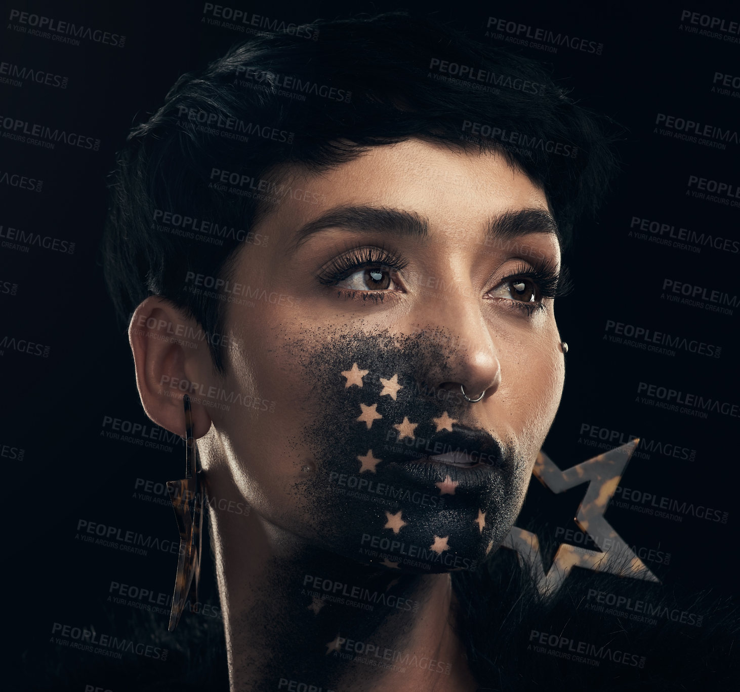 Buy stock photo Studio shot of a young woman posing with paint on her face on a black background