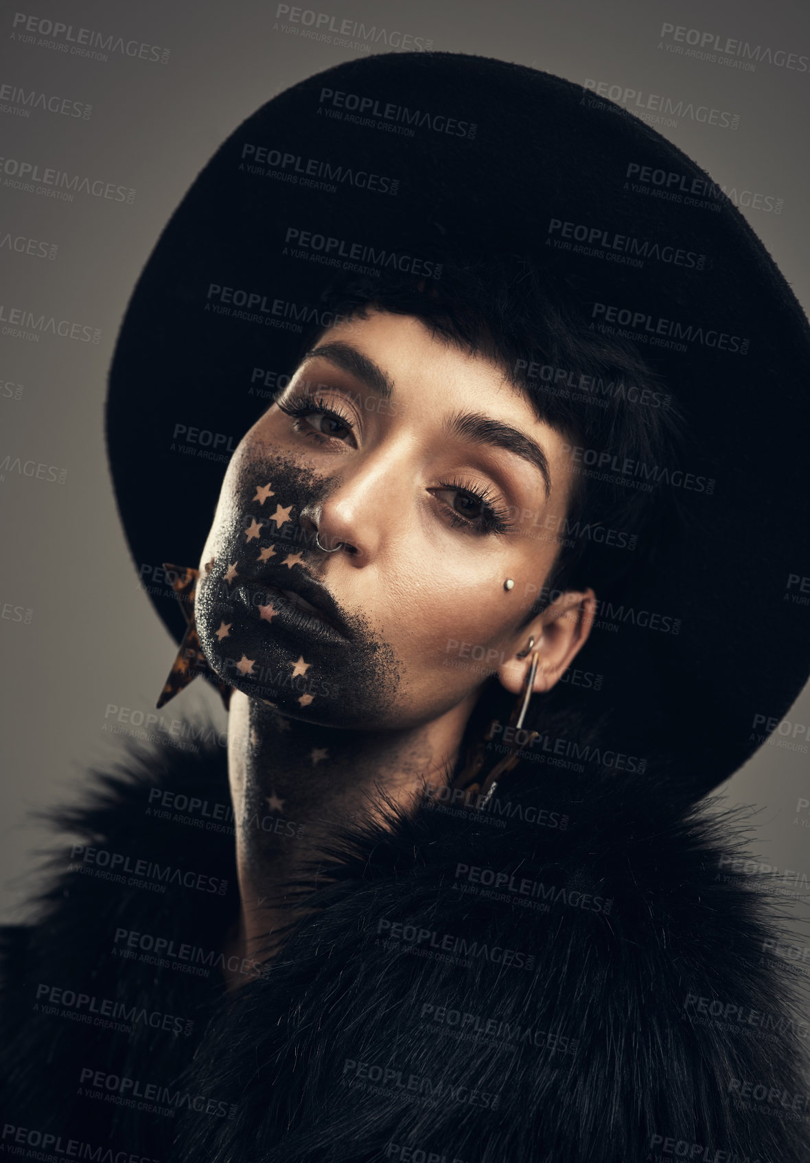 Buy stock photo Studio shot of a young woman posing with paint on her face on a grey background