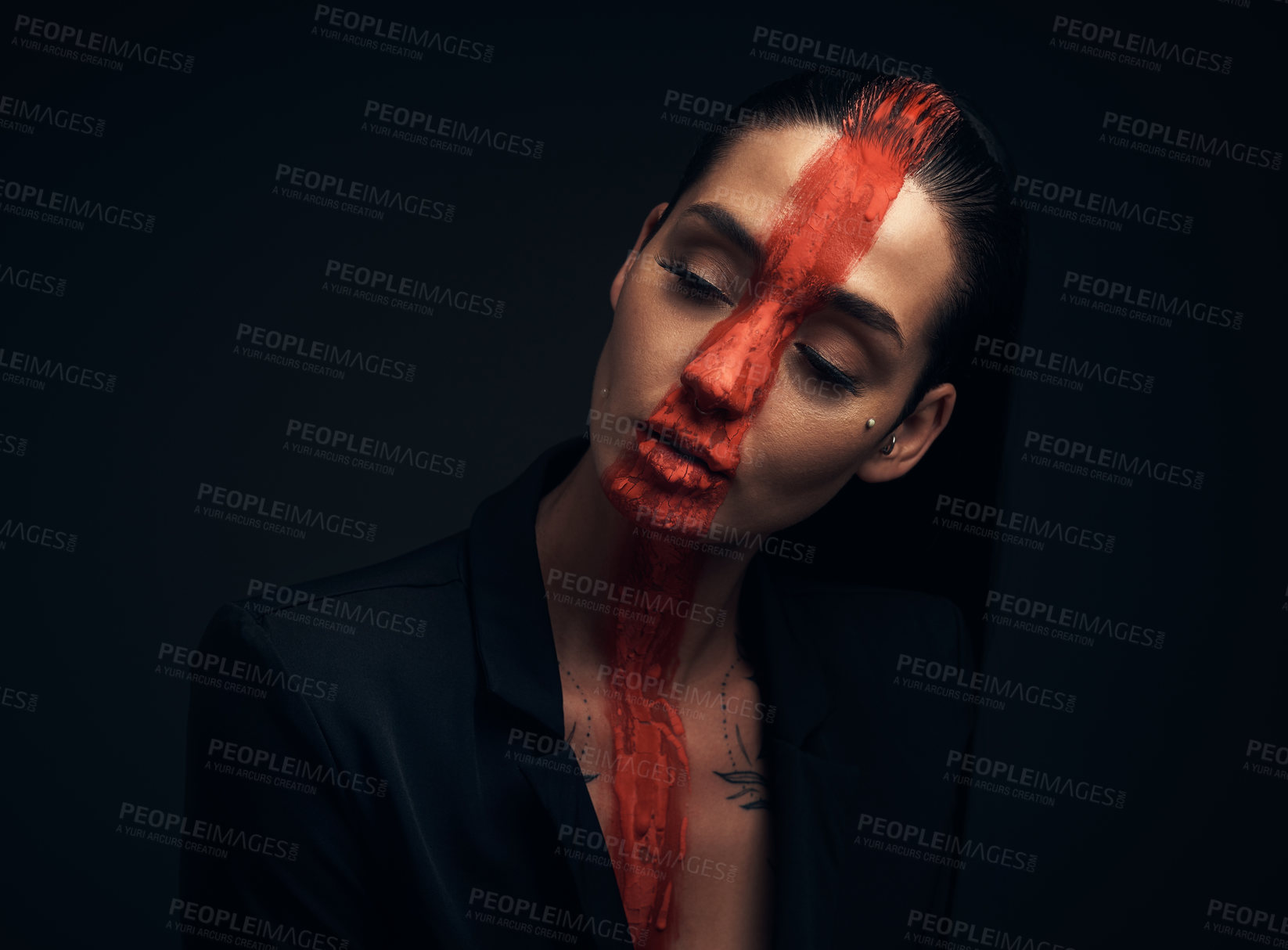 Buy stock photo Studio shot of a young woman posing with paint on her face on a black background