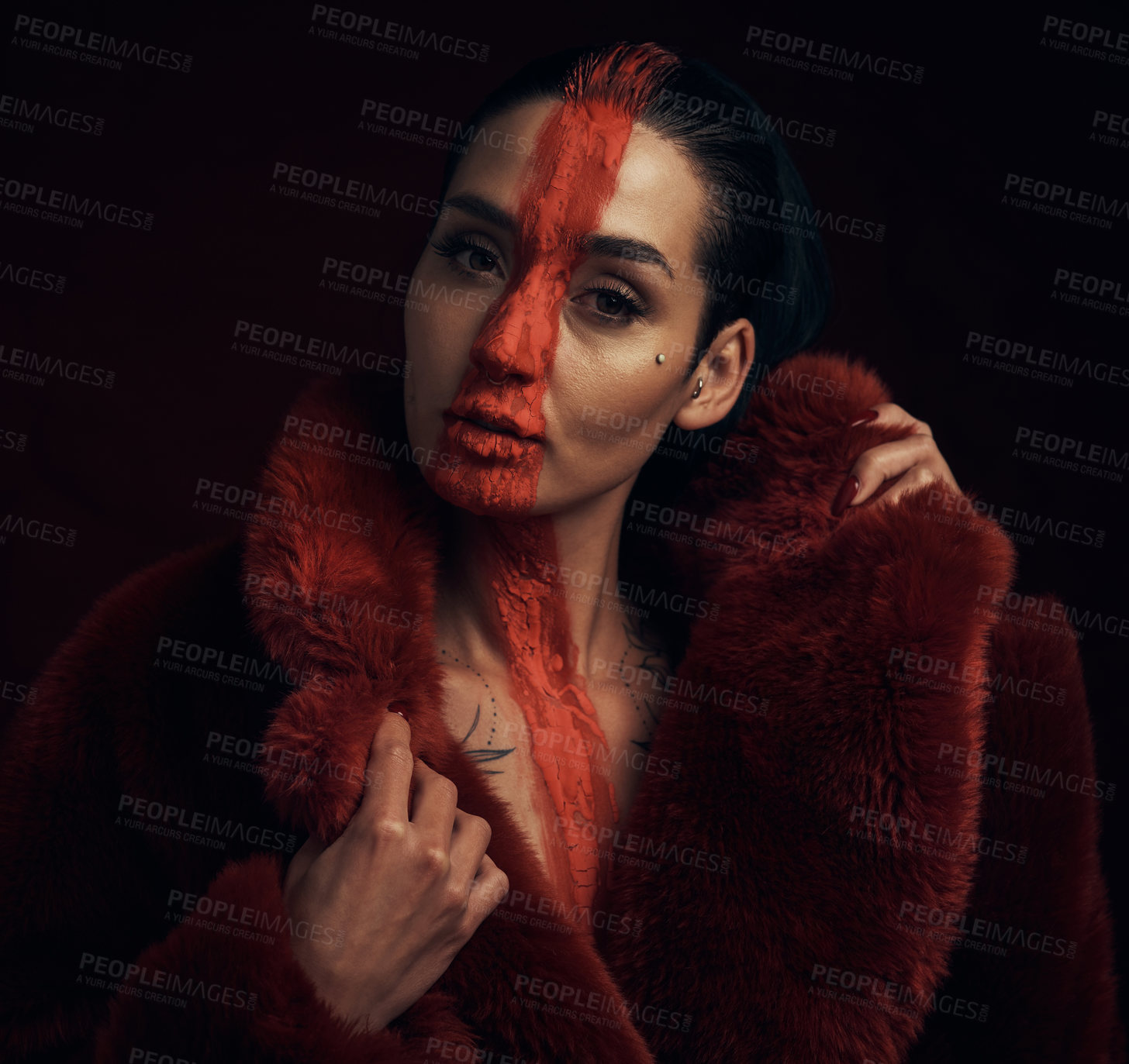 Buy stock photo Studio shot of a young woman posing with paint on her face on a black background