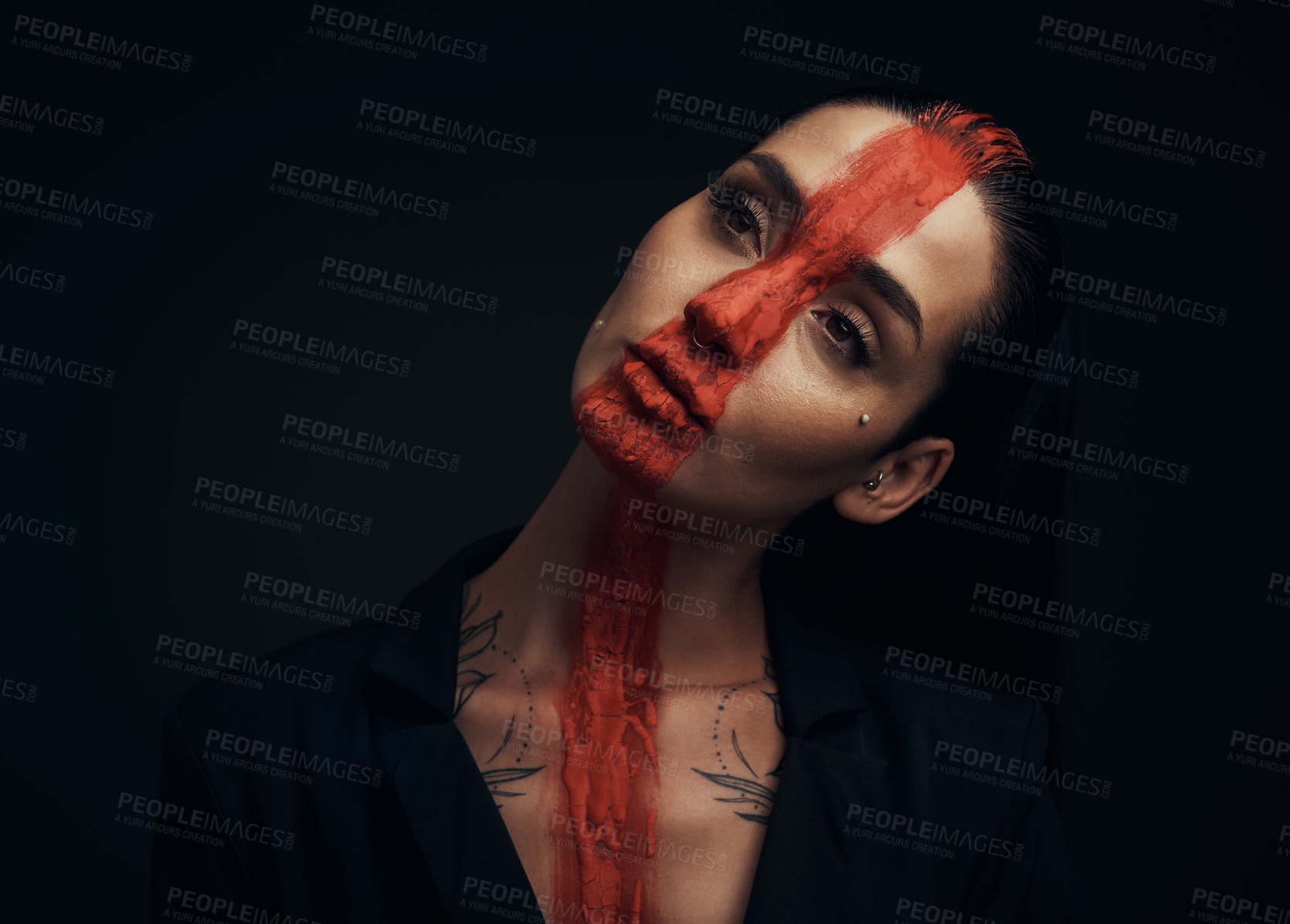 Buy stock photo Studio shot of a young woman posing with paint on her face on a black background