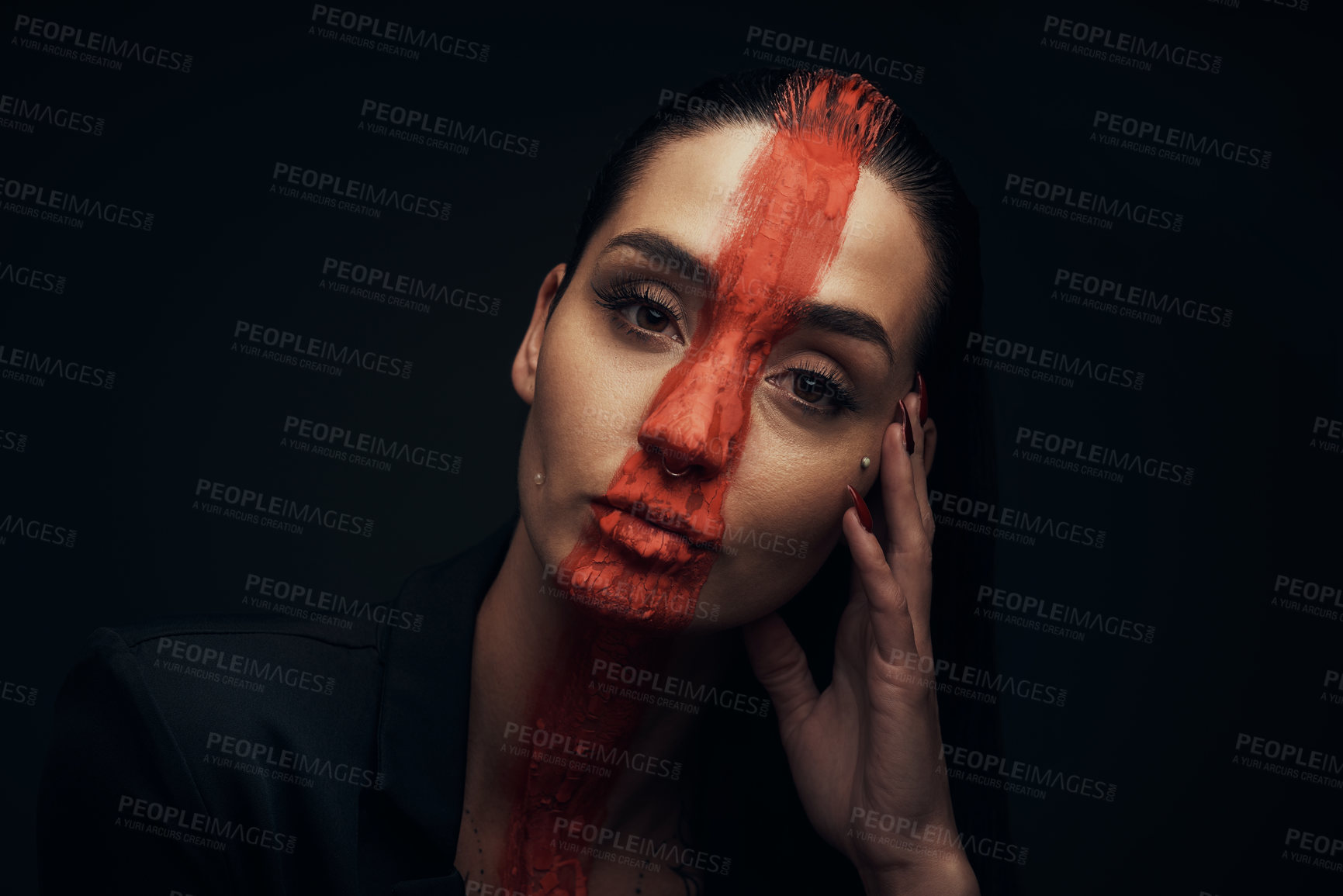 Buy stock photo Studio shot of a young woman posing with paint on her face on a black background