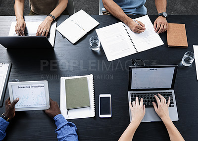 Buy stock photo Shot of a team of businesspeople using various tech devices in their office