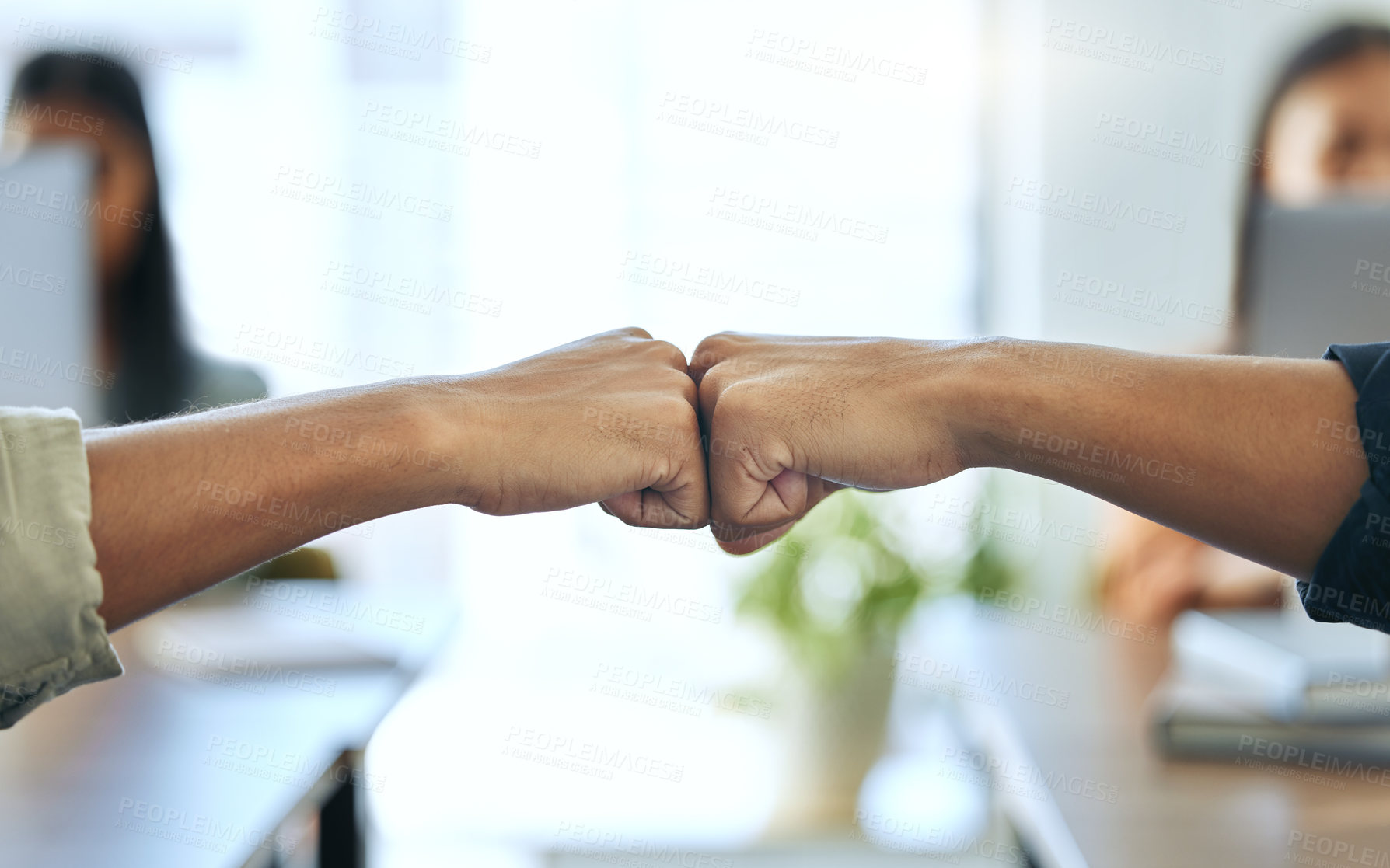 Buy stock photo Cropped shot of two unrecognizable businesspeople sitting together in the office and giving each other a fist bump