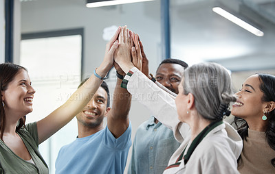 Buy stock photo Shot of a group of businesspeople giving each other a high five in an office