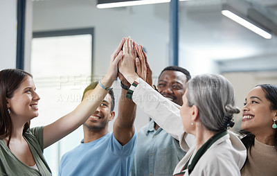 Buy stock photo Shot of a group of businesspeople giving each other a high five in an office