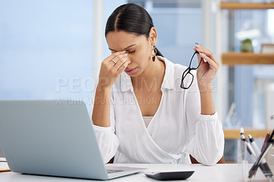 Buy stock photo Shot of a young businesswoman sitting at a desk looking overwhelmed in a modern office