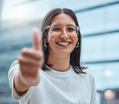 Buy stock photo Shot of a young businesswoman showing thumbs up against an urban background