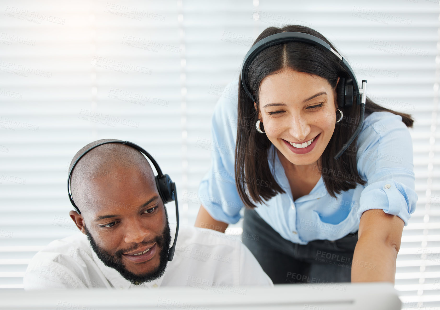 Buy stock photo Shot of a handsome young salesman sitting in the office and wearing a headset while getting help from his manager