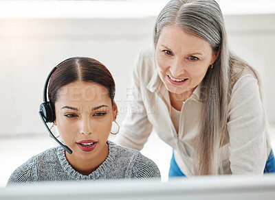 Buy stock photo Shot of an attractive young call centre agent sitting in the office and getting help from her manager