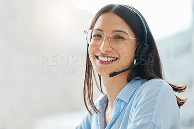Buy stock photo Shot of an attractive young saleswoman sitting alone in the office and wearing a headset